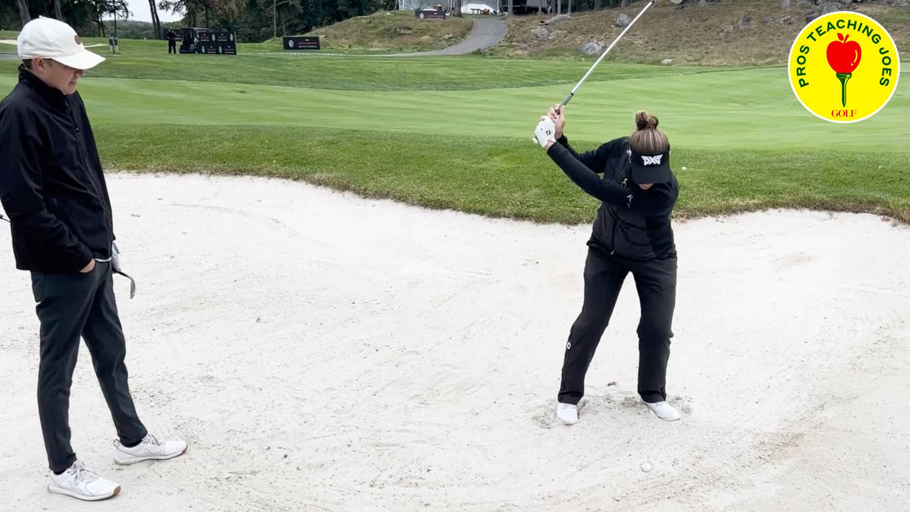 brittany lang hits fried egg shot from the bunker while GOLF editor zephyr melton looks on