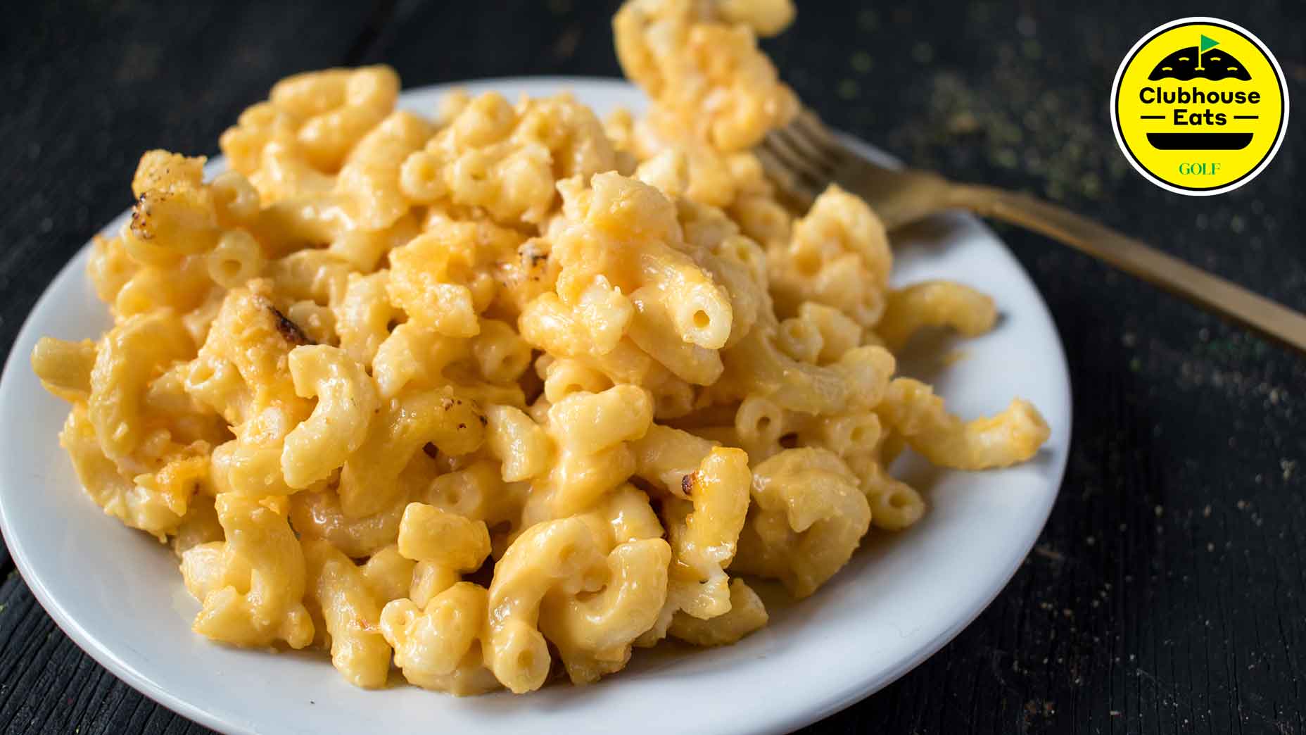 a plate of mac and cheese served on a dark table